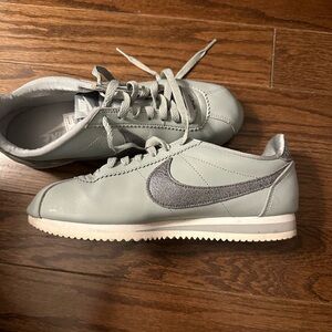 Nike Cortez, light greenish blue with a silver Nike symbol.